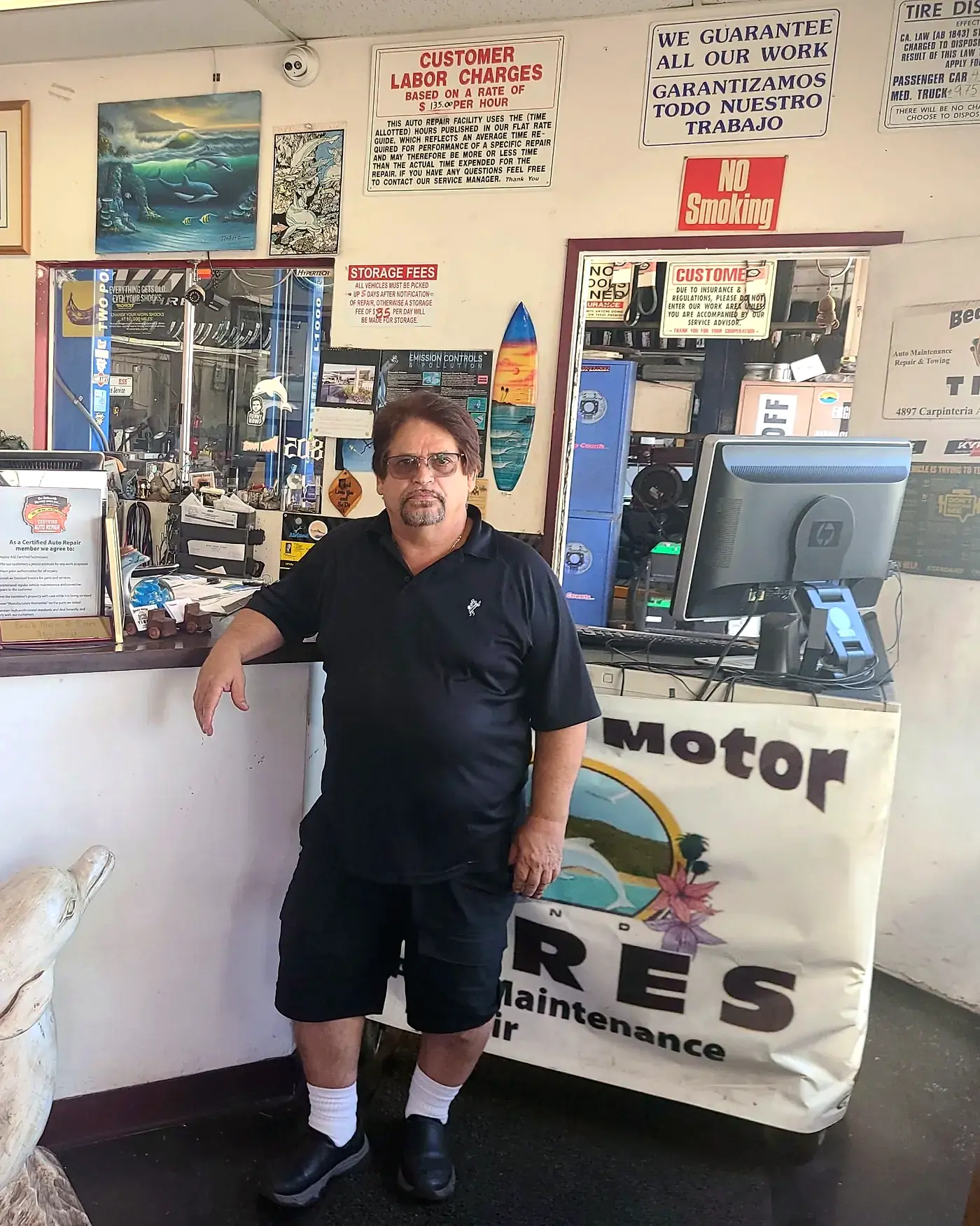 Abel Zuniga at the front counter beside a carved dolphin