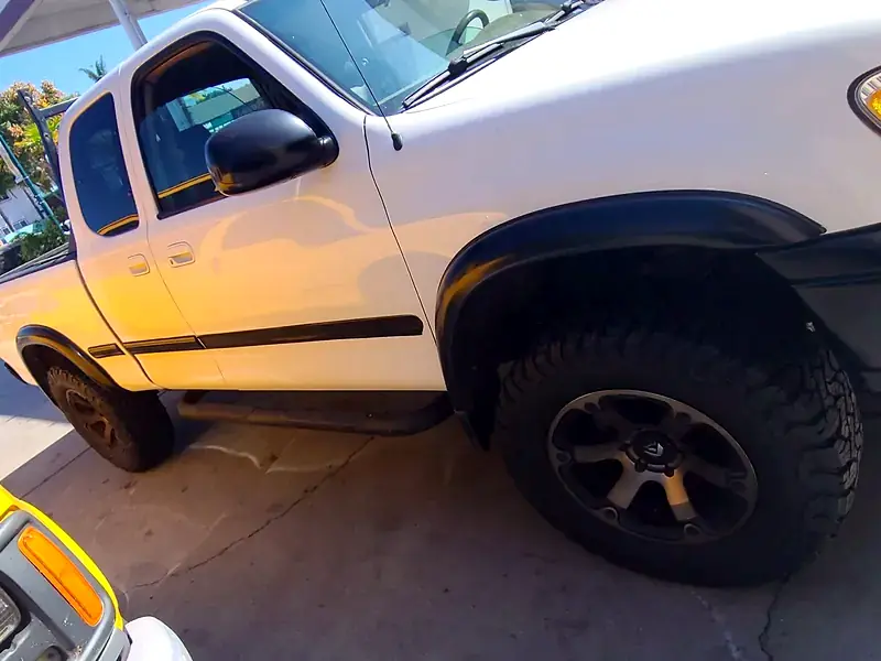 A white Toyota Tundra under the canopy with its new set of all-terrain tires